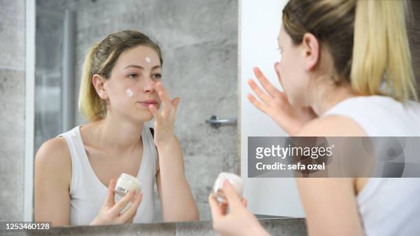 applying face cream - applying cream stock pictures, royalty-free photos & images