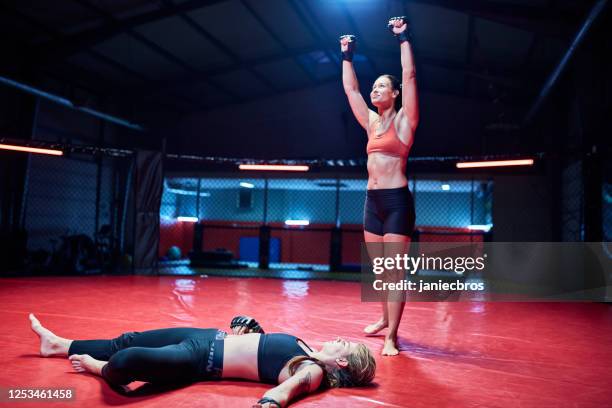 female mma fighters training in octagon. knock out - boxer knockout stock pictures, royalty-free photos & images