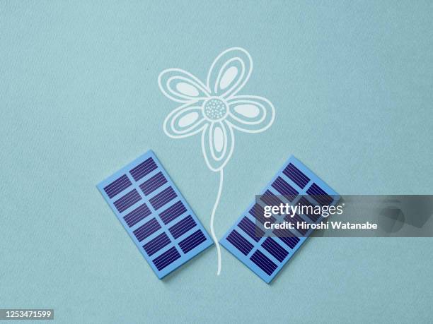 mini solar panel and flower drawing on paper - convenienza foto e immagini stock