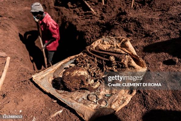 A skull and other parts of a body are gathered by volunteers while ...