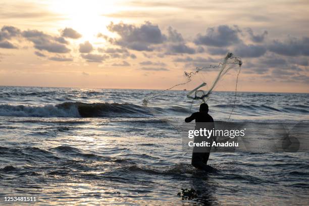 Fisherman catches a fish with a net at Meydan village during sunset in Samandag district of Hatay, Turkiye on May 08, 2023. Fishing in the village of...