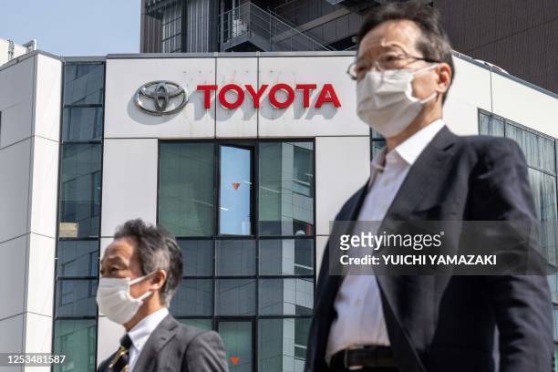 Pedestrians walk past a car dealership for Japanese automaker Toyota in Tokyo on May 10, 2023. Top-selling automaker Toyota said on May 10 that its...