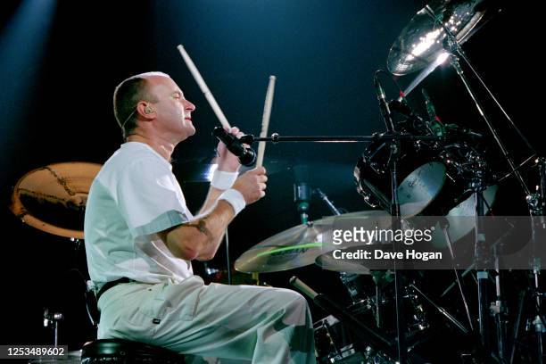 Phil Collins drumming during a performance on stage circa 1995