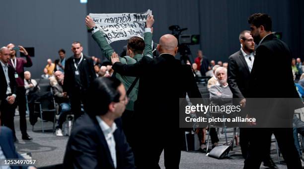 Activists are taken out of the room at the Volkswagen AG General Assembly - Annual General Meeting 2023. Photo: Britta Pedersen/dpa