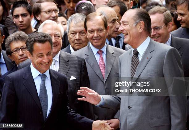 French President Jacques Chirac talks with President-elect Nicolas Sarkozy as National Assembly chairman Patrick Ollier looks on, 10 May 2007 at the...