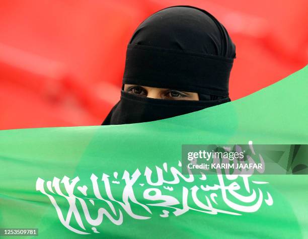 Saudi football fan cheers for her team before the start of the 2011 Asian Cup group B football match between Jordan and Saudi Arabia at Al-Rayyan...