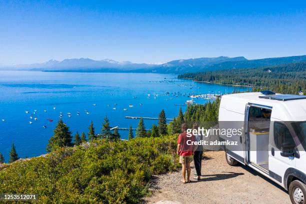 young couple parked van at a viewpoint of lake tahoe - camper van imagens e fotografias de stock