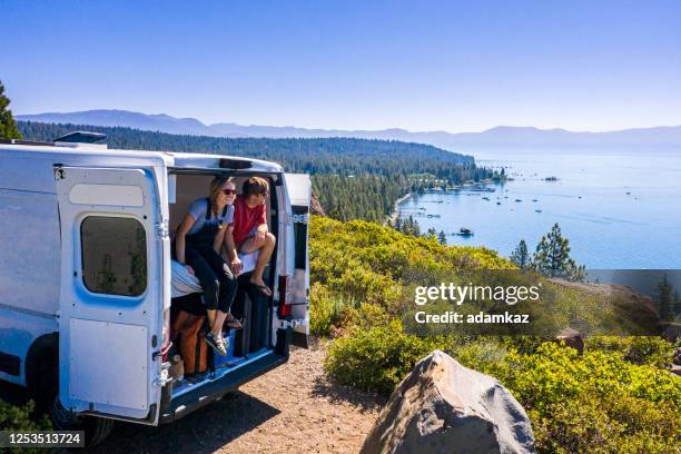 joven pareja estacionada van en un mirador del lago tahoe - caravana fotografías e imágenes de stock