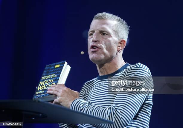 Benjamin von Stuckrad-Barre, author and journalist, reads from his book "Still awake?" on stage at the OMR digital trade fair in the exhibition...