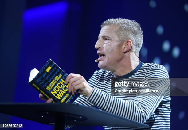 Benjamin von Stuckrad-Barre, author and journalist, reads from his book "Still awake?" on stage at the OMR digital trade fair in the exhibition...