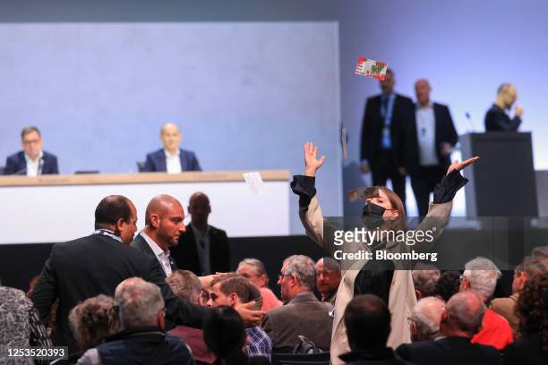 Protester throws fake 100 Euro banknotes at the Volkswagen AG annual general meeting in the CityCube Berlin conference centre in Berlin, Germany, on...