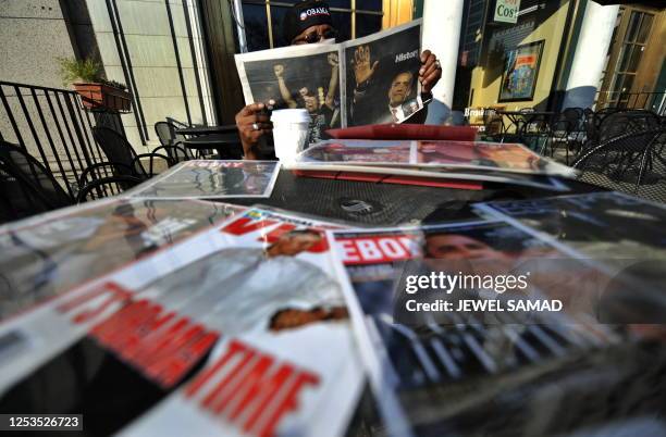 Man reads a newspaper carrying front page news about US President-elect Barack Obama in Chicago, Illinois, on November 5, 2008. Obama swept to an...