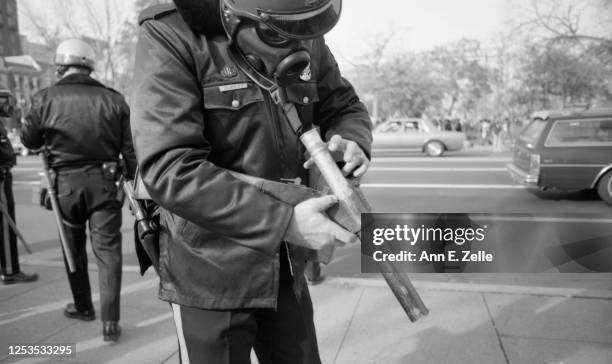 Close-up of a police officer as he loads a cartridge into a tear gas gun , Washington DC, November 27, 1982. The police had been deployed for a...