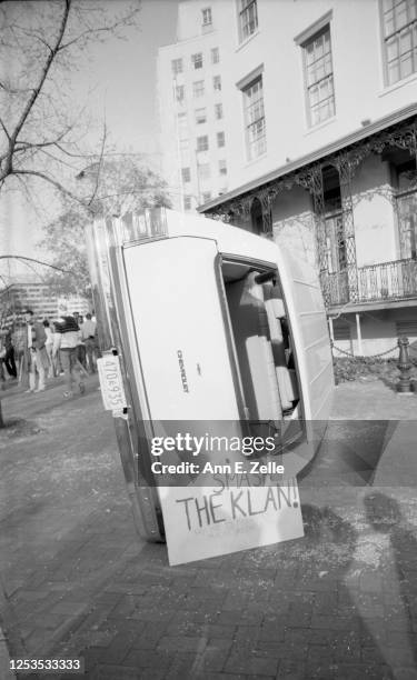 View of a Chevrolet station wagon, tipped on its side during an anti-KKK demonstration, in front of the CuttsÐMadison House , Washington DC, November...