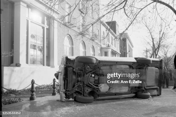 View of a Chevrolet station wagon, tipped on its side during an anti-KKK demonstration, on H Street NW , Washington DC, November 27, 1982. A Ku Klux...