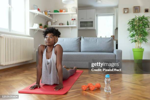 female in sportswear is doing cobra pose - cobra stretch stock pictures, royalty-free photos & images