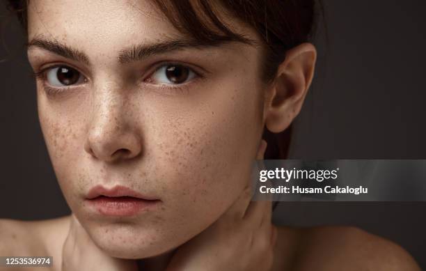 freckled schöne frau porträt front von grauem hintergrund - ausdruckslos stock-fotos und bilder