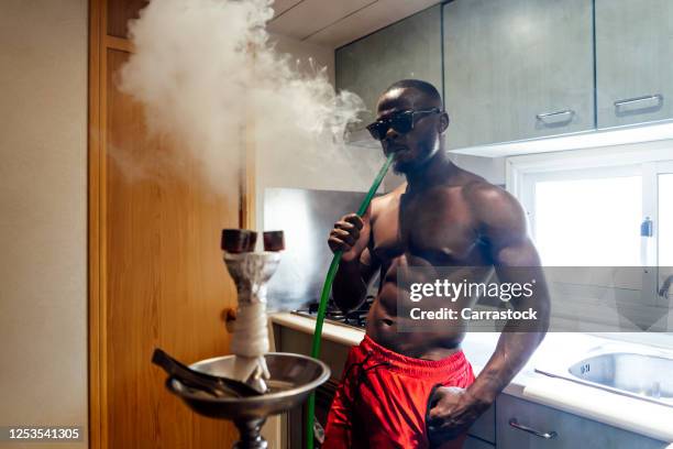 african man smoking a hookah. - hookah stock pictures, royalty-free photos & images