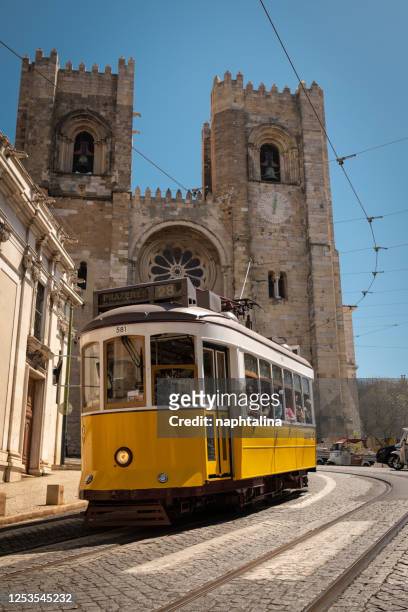 traditional yellow tram driving on r. augusto rosa street towards lisbon cathedral - lisbon tram stock pictures, royalty-free photos & images