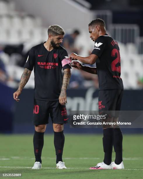 Fernando Reges of Sevilla FC puts the captain´s armband to his teammate Ever Banega during the Liga match between CD Leganes and Sevilla FC at...