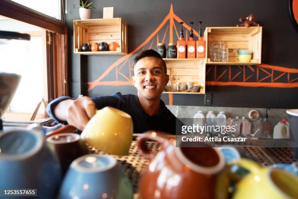 happy barista putting coffee cups to place after reopening - opening event stock pictures, royalty-free photos & images