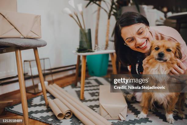 frau wickelt öko-geschenke - dog knotted in woman stock-fotos und bilder