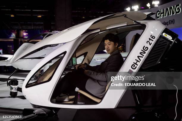 Visitor sits inside an EHang 216 flying car at the BEYOND Expo 2023, a technology exhibition, in Macau on May 10, 2023.