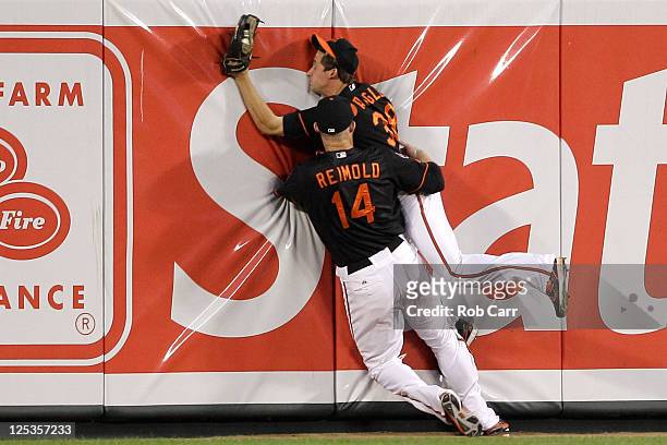 Centerfielder Matt Angle of the Baltimore Orioles collides with right fielder Nolan Reimold after catching a ball for an out hit by Howard Kendrick...