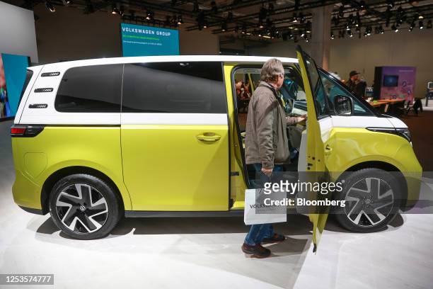 An attendee inspects the interior of VW ID Buzz electric van on display at the Volkswagen AG annual general meeting in the CityCube Berlin conference...