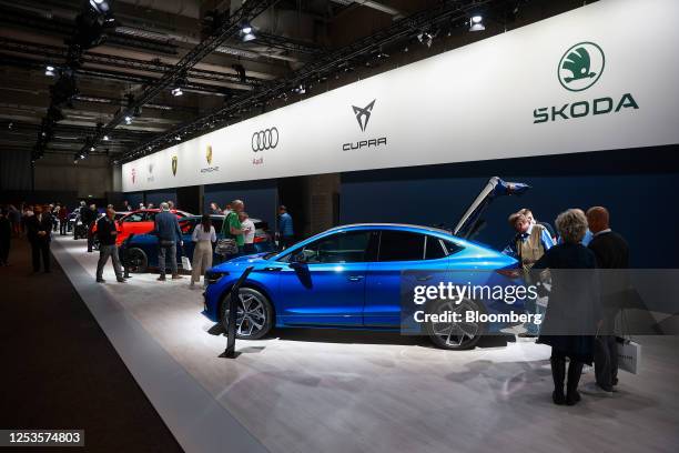 Attendees inspect a Skoda Enyaq RS iV all-electric SUV on display at the Volkswagen AG annual general meeting in the CityCube Berlin conference...