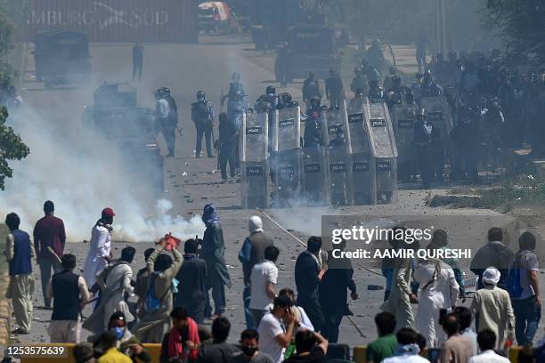 Pakistan Tehreek-e-Insaf party activists and supporters of former Pakistan's Prime Minister Imran Khan clash with policemen during a protest against...