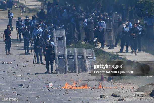 Policemen stand guard during the clash with Pakistan Tehreek-e-Insaf party activists and supporters of former Pakistan's Prime Minister Imran Khan...