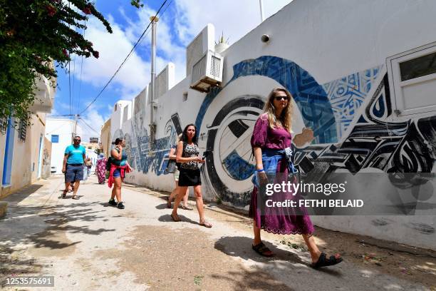 Tourists walk through the alleys of the Hara Kebira, the main Jewish quarter in the resort island of Djerba, where the Ghriba synagogue is located,...