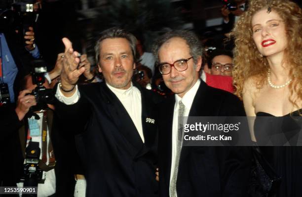 Alain Delon, director Jean Luc Godard and actress Domiziana Giordano attend the 43th Cannes film Festival in May 1990, in Cannes, France.