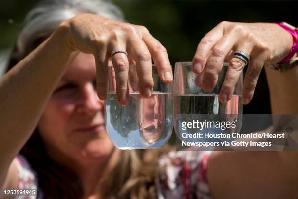 Dr. Teri Albright compares a water sample from her well, left, and compares it to a glass full of bottled water on Monday, May 11, 2020 in Blanco,...