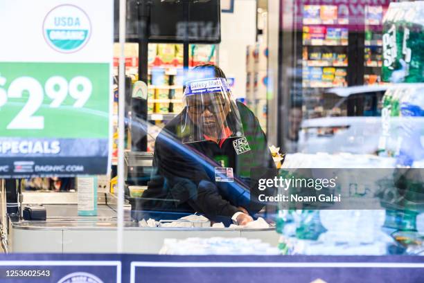 Worker wears a face mask in a D'Agostino supermarket in Murray Hill as New York City moves into Phase 2 of re-opening following restrictions imposed...