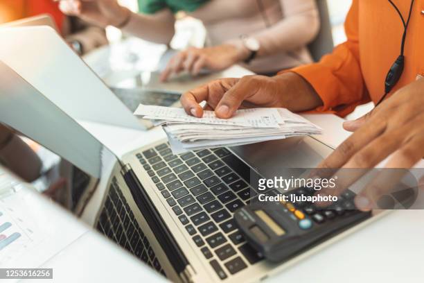 person paying invoice to computer - expense receipts stock pictures, royalty-free photos & images