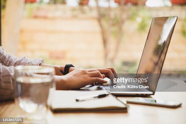 asian woman using a laptop at home - werk zoeken stockfoto's en -beelden