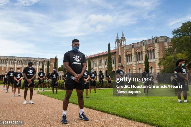 Rice University football player Ikenna Enechukwu, center, left, stands with a group of his teammates following a march across campus in a show of...