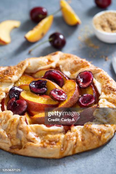 galette pie with peaches and cherries - sauerkirsche stock-fotos und bilder