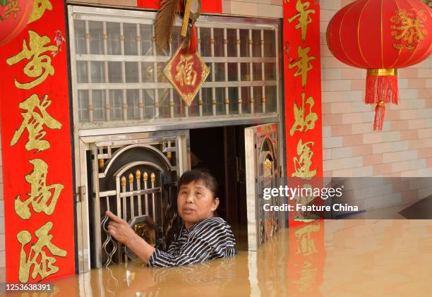 Villager looks up to the rescuers coming to evacute people trapped in houses in a flash flood caused by torrential rains in Zhangshu city in central...