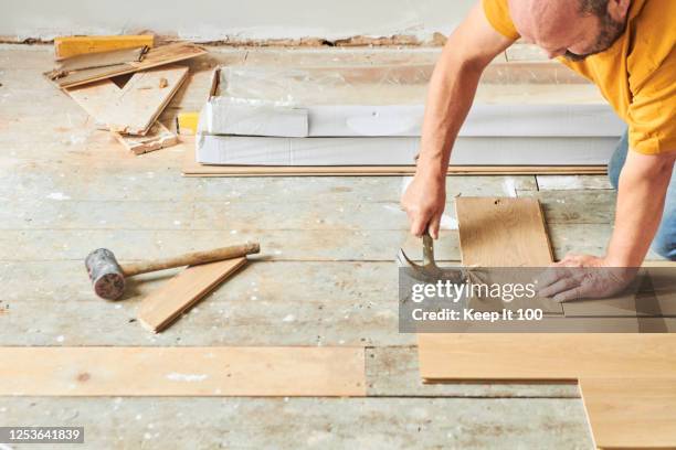 carpenter laying new wood flooring - flooring installation stock pictures, royalty-free photos & images