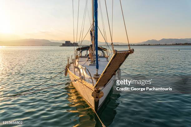 front side of sailing boat at sunset - aangemeerd stockfoto's en -beelden