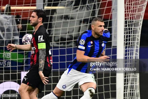 Inter Milan's Bosnian forward Edin Dzeko celebrates next to AC Milan's Italian defender Davide Calabria after opening the scoring during the UEFA...