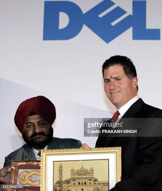 Personal computer giant Dell Inc Chairman Michael Dell poses for picture with paintings during the inauguration of a customer contact center, in...