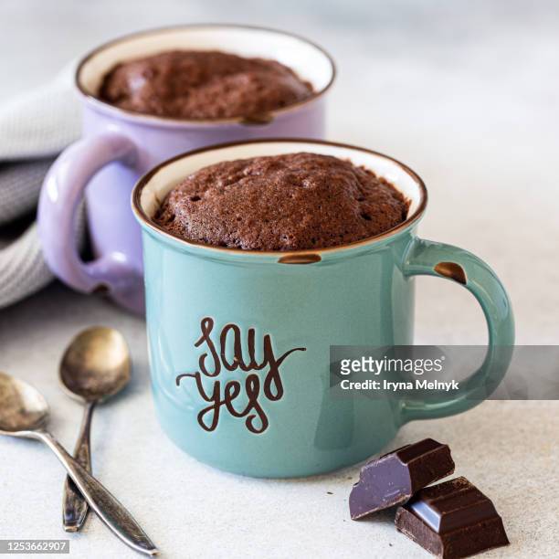 chocolate mug cakes in vintage colorful cups on gray background. fast cooking in the microwave. copy space. - mug photos et images de collection