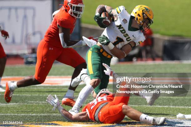 North Dakota State wide receiver Christian Watson is tripped up for a loss by Sam Houston State defensive back Braiden Clopton during the third...