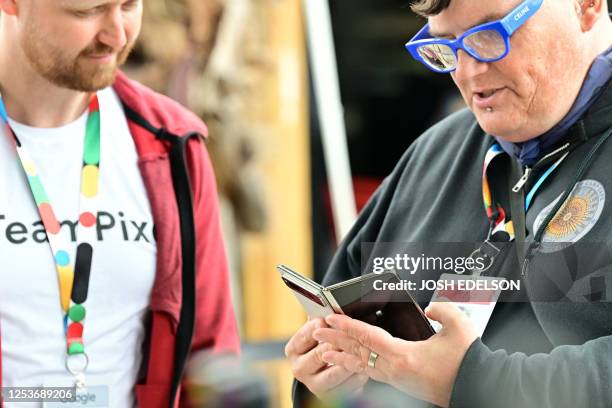 Members of the media view the new Google Pixel Fold phone during the Google I/O annual developers conference at Shoreline Amphitheatre in Mountain...