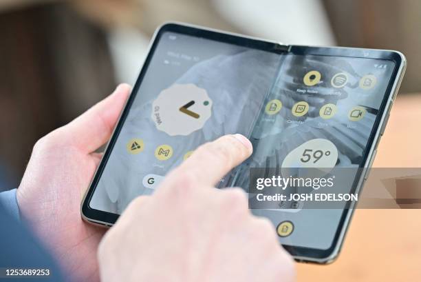 Members of the media view the new Google Pixel Fold phone during the Google I/O annual developers conference at Shoreline Amphitheatre in Mountain...