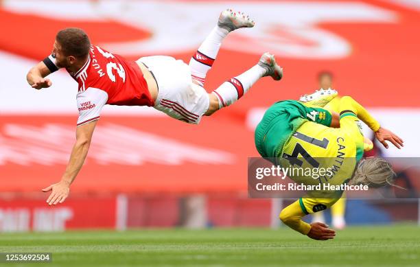 Shkodran Mustafi of Arsenal and Todd Cantwell of Norwich City collide as they compete for a header during the Premier League match between Arsenal FC...